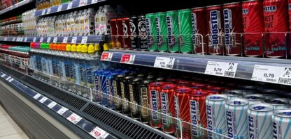 Cans frisdrank en bruisend drankje geselecteerd op Apotheek Kassa, drankregal in supermarkt, grote collectie frisdrank, kombucha en energiedrank, kleurrijk en aantrekkelijk gepresenteerd.