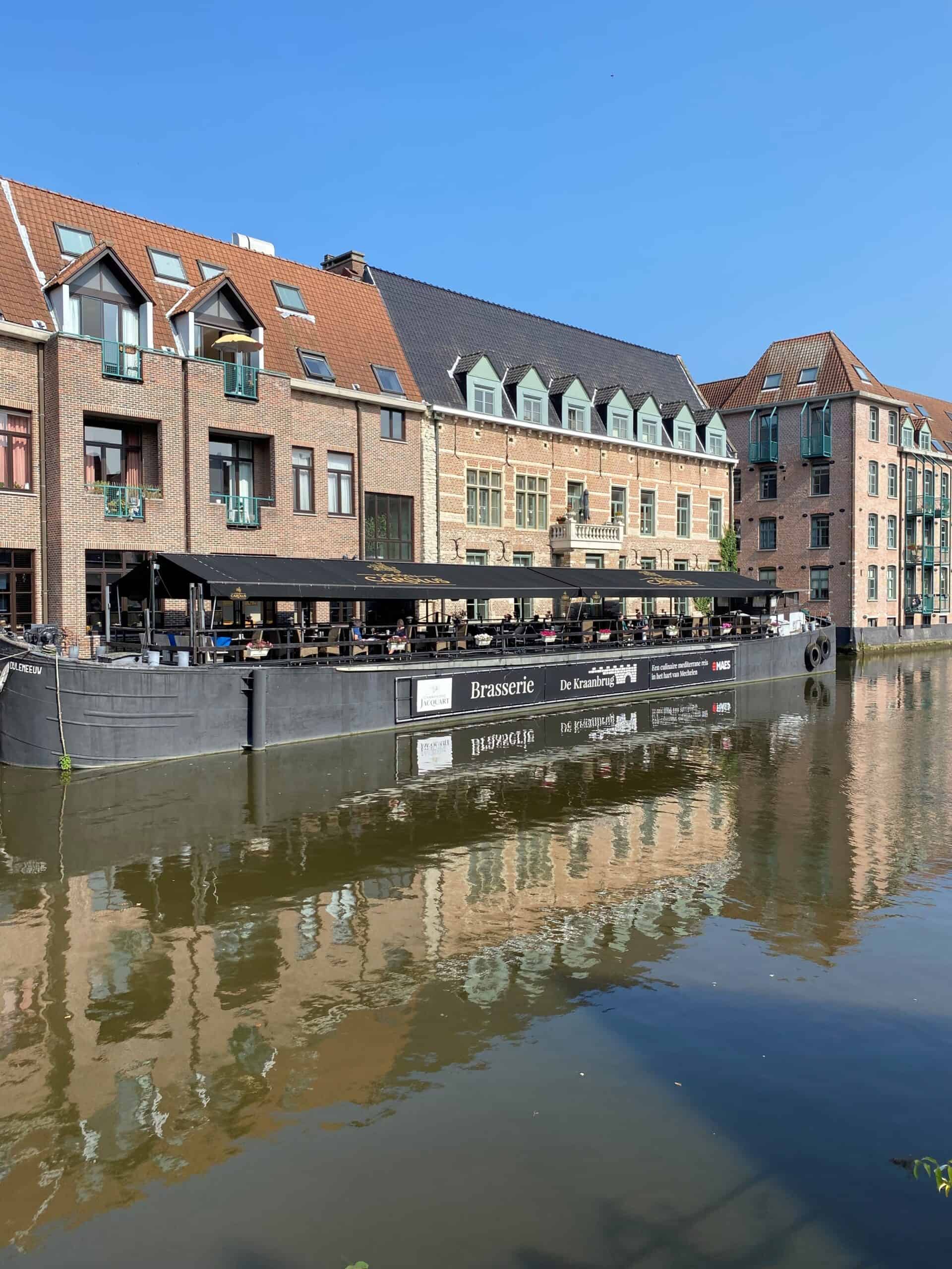 Mooie houseboats en historische gebouwen langs de waterkant in Antwerpen, Belgïe. Perfecte plek voor ontspanning en genieten van de sfeer van de stad.