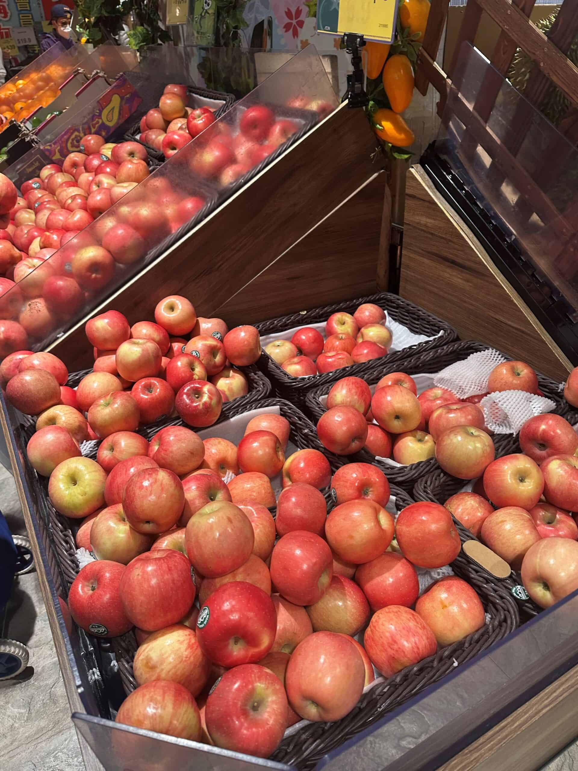 Apples in winkelmandje en display bij supermarkt.