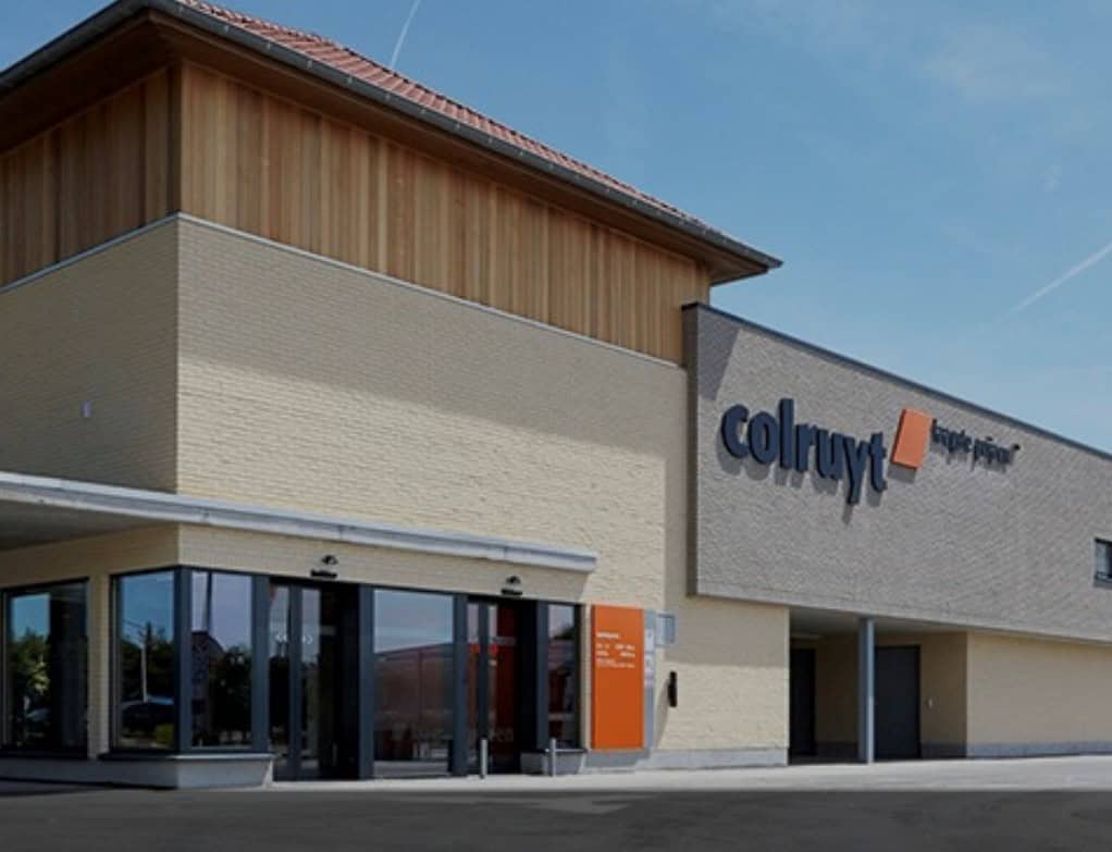 Modern bedrijfsgebouw met branding van Colruyt, geoptimaliseerd voor retail en logistiek, met energiebesparende en duurzame oplossingen.