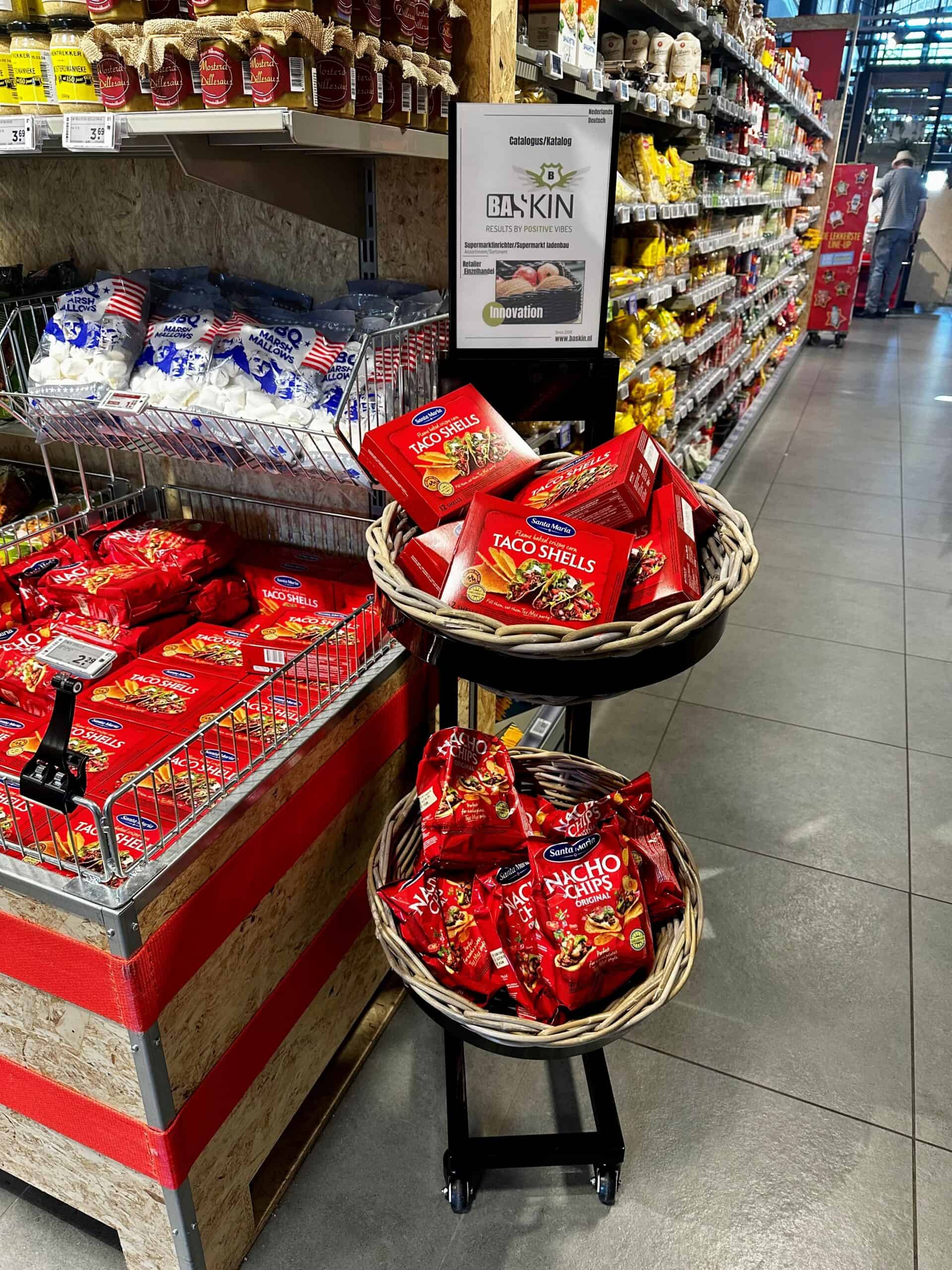 Taco shells en nacho chips in rode verpakkingen, bij de supermarkt, assortiment snacks, snackproducten, winkeldisplay, retail, supermarkt, tortilla chips, Mexicaanse snacks, smaakvolle hapjes, food retail, snackaanbieding, koopgemak, winkelinrichting.