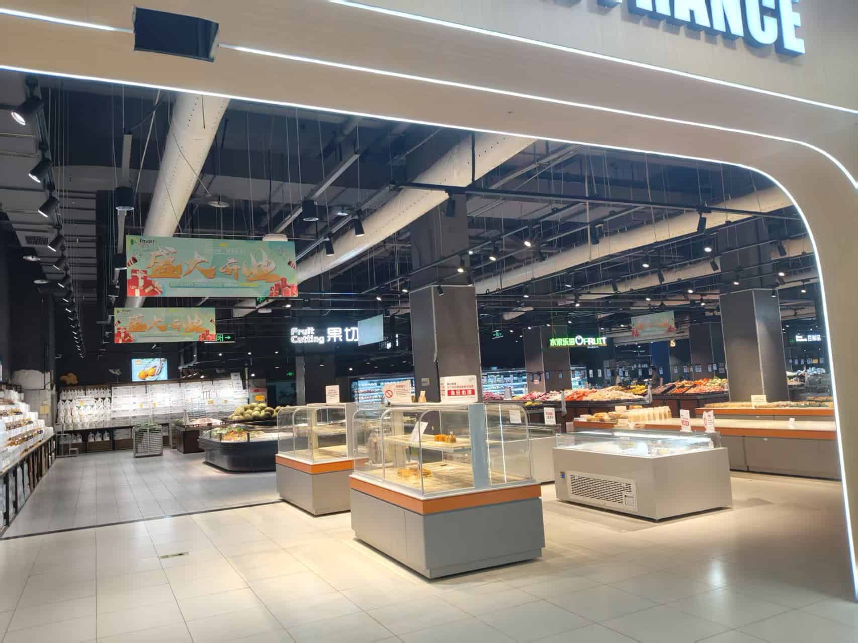 Hoge resolutie afbeelding van een moderne supermarkt met verlichte toonbank en verse producten, gericht op innovatieve retail oplossingen en klantgericht design door Elips Solutions.