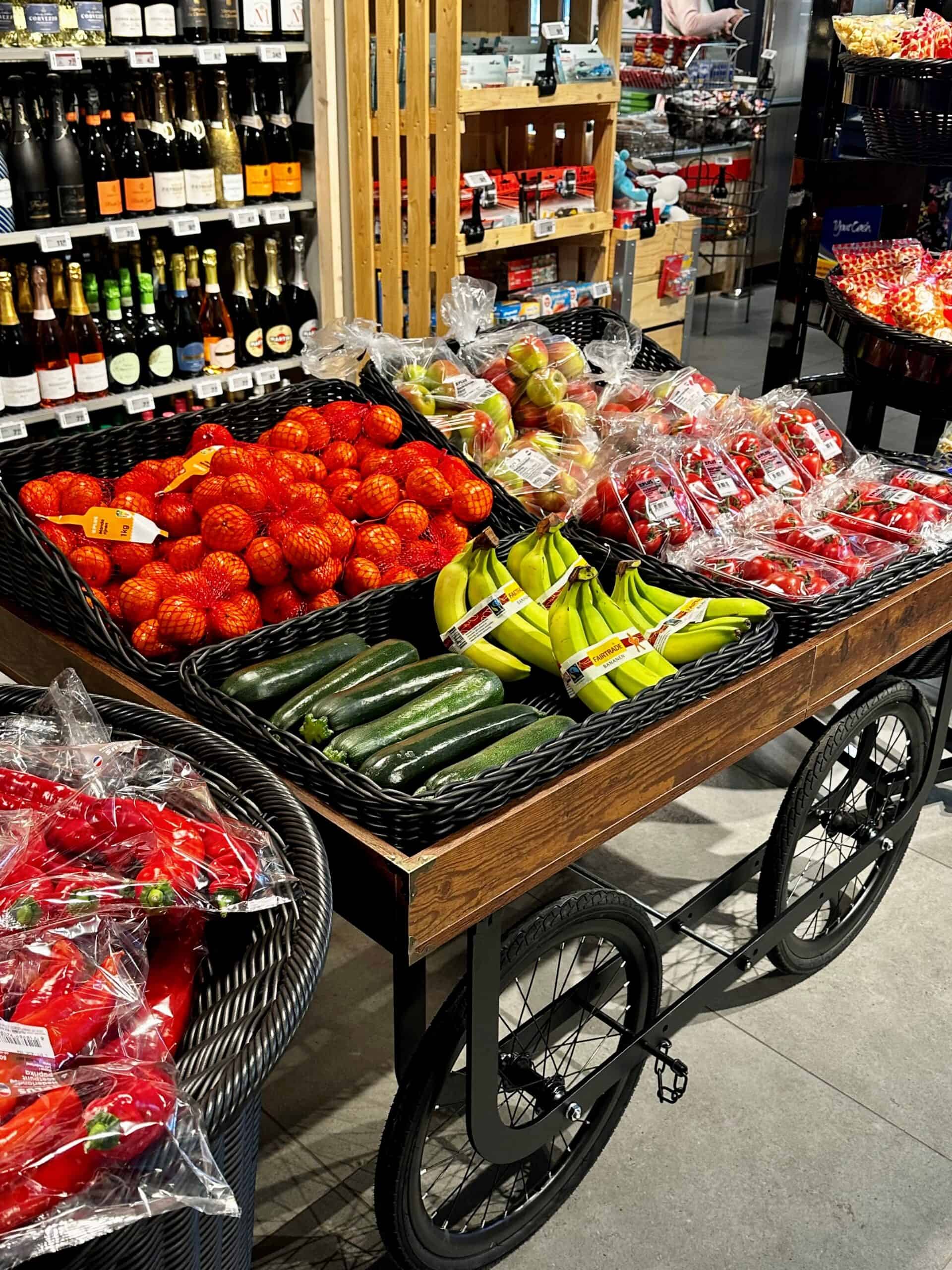 Verse groenten en fruit in slimme winkelwagen, ideaal voor gezonde aankopen, bij Elips Solutions supermarkt, met een assortiment van tomaten, komkommers, bananen en appels, in een moderne winkelomgeving.