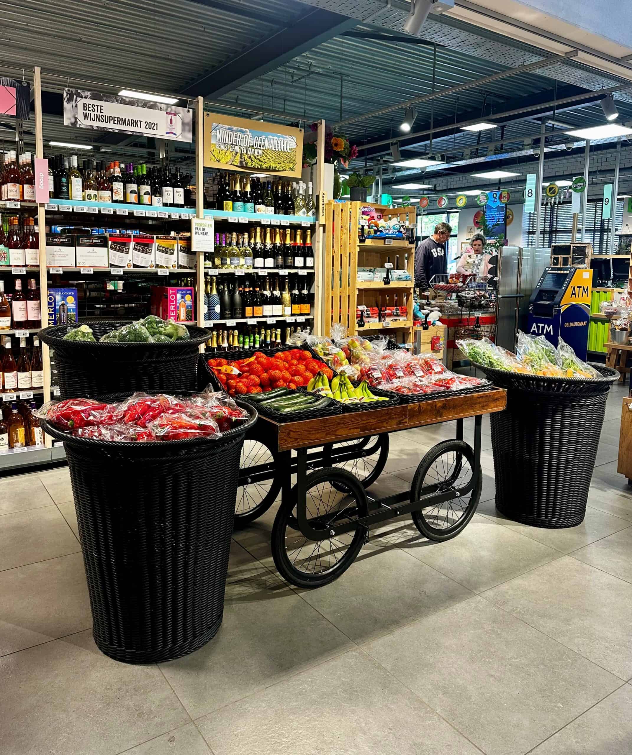 Bio-producten en verse groenten en fruit, gepresenteerd op een stijlvol winkelwagenvormig display in een supermarkt. Ideaal voor gezonde voeding en versproducten.