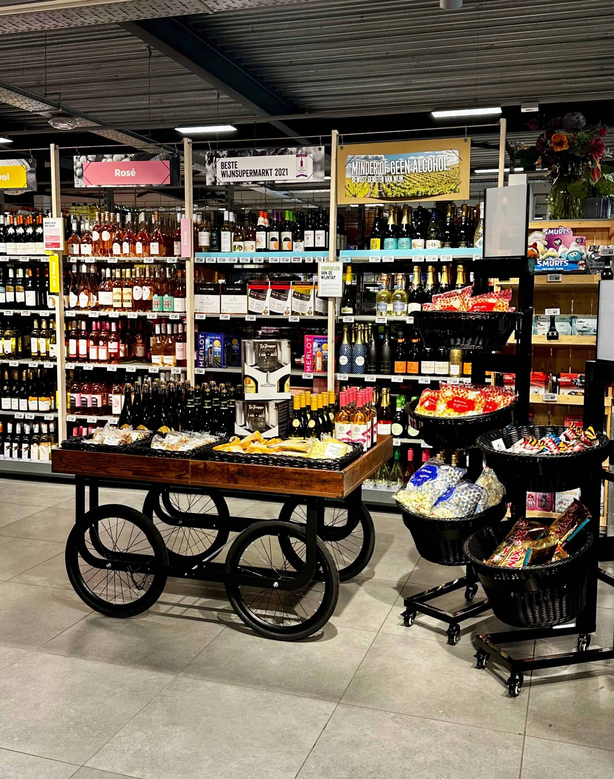 Wijn - Supermarkt wijnafdeling met assortiment rode, witte en roséwijnen, display met wijnproducten en promotiebanners, op zoek naar premium wijnservice en ruime keuze.
