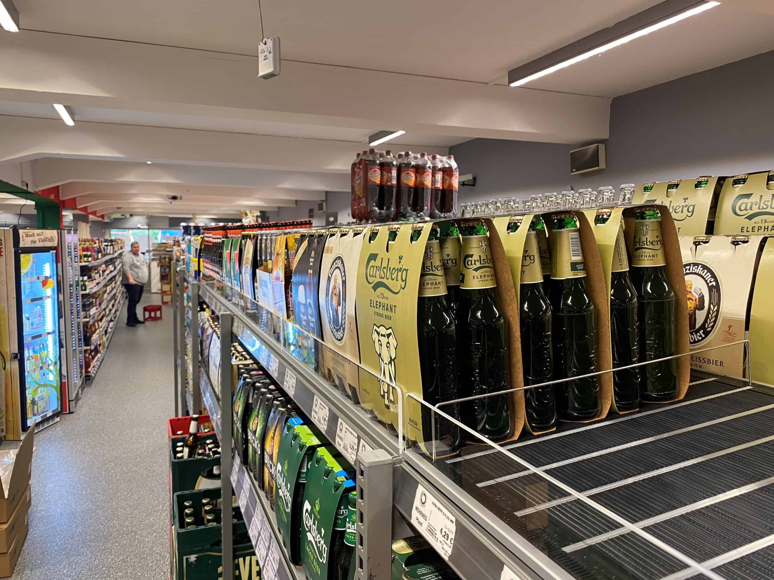 Carlsberg Elephant bier op winkelrek in supermarkt, focus op frisdranken en bierdiversiteit, promotie van kwaliteitsbier en gemak voor klanten, overzichtelijk winkelonrichting.