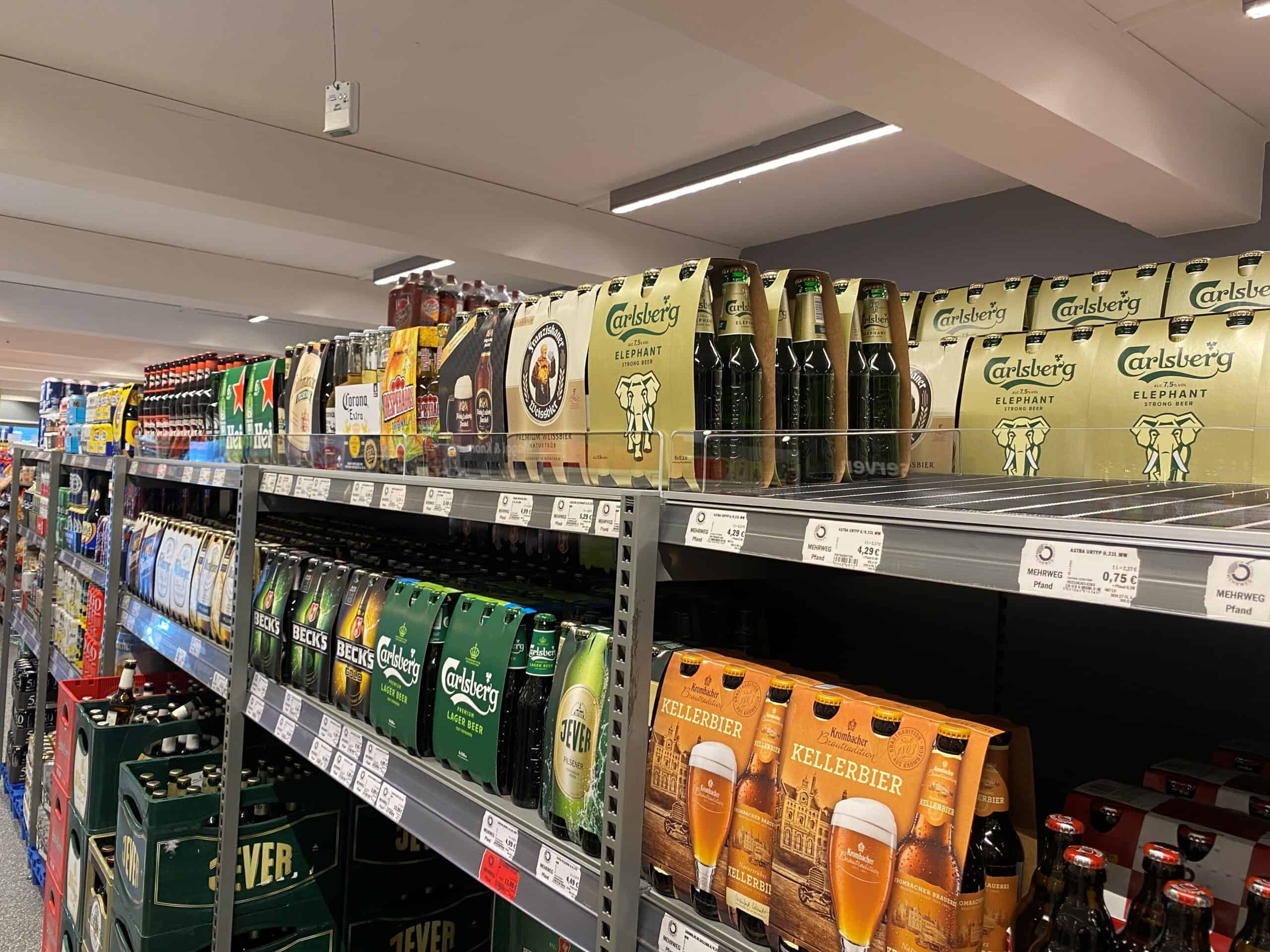 Stapel met verschillende soorten bier op supermarkt shelf, inclusief Carlsberg Elephant, Kellerbier en andere populaire merken, geschikt voor retail en horecazaken.