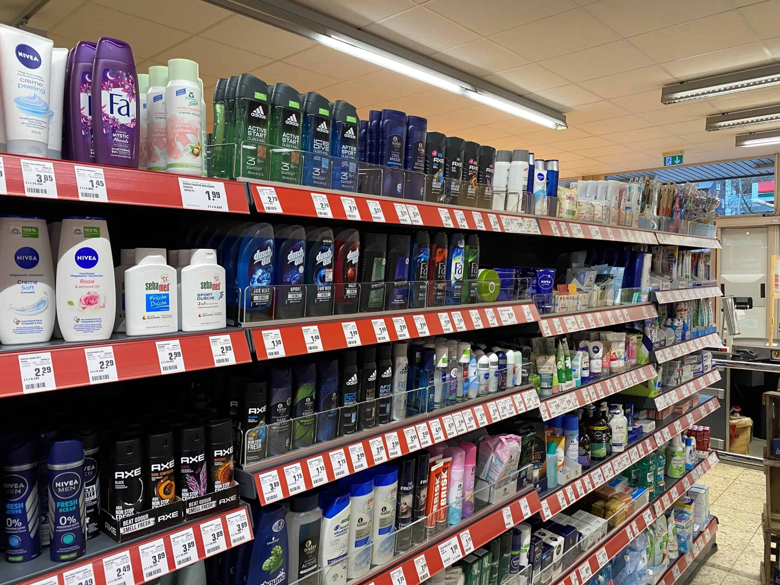 Gezicht, lichaam en verzorgingsproducten op een supermarktreling, inclusief deodorants, scheerschuim en huidverzorging. Perfect voor personal care en gezondheidsproducten in de retailsector.