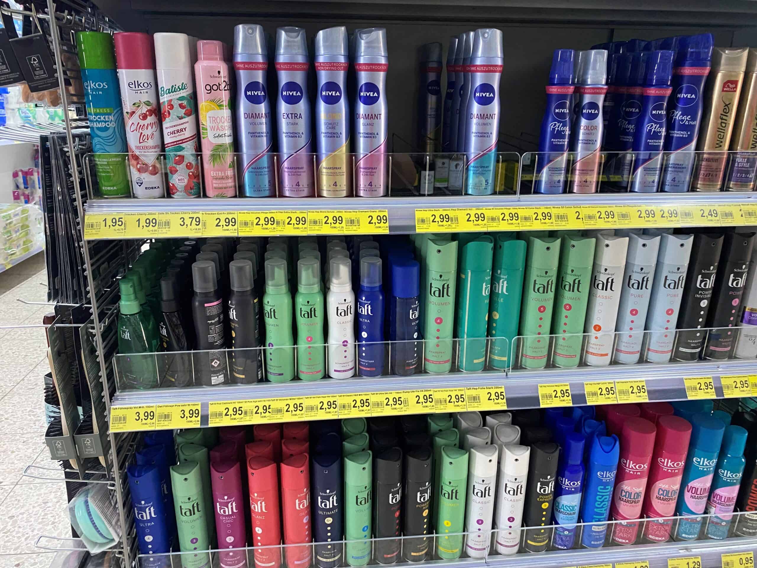 Elfek lift haarproducten, shampoos en stylingspray op een winkelrek, gericht op haarverzorging en styling, met diverse merken en functies, aantrekkelijk voor kappers en consumenten.