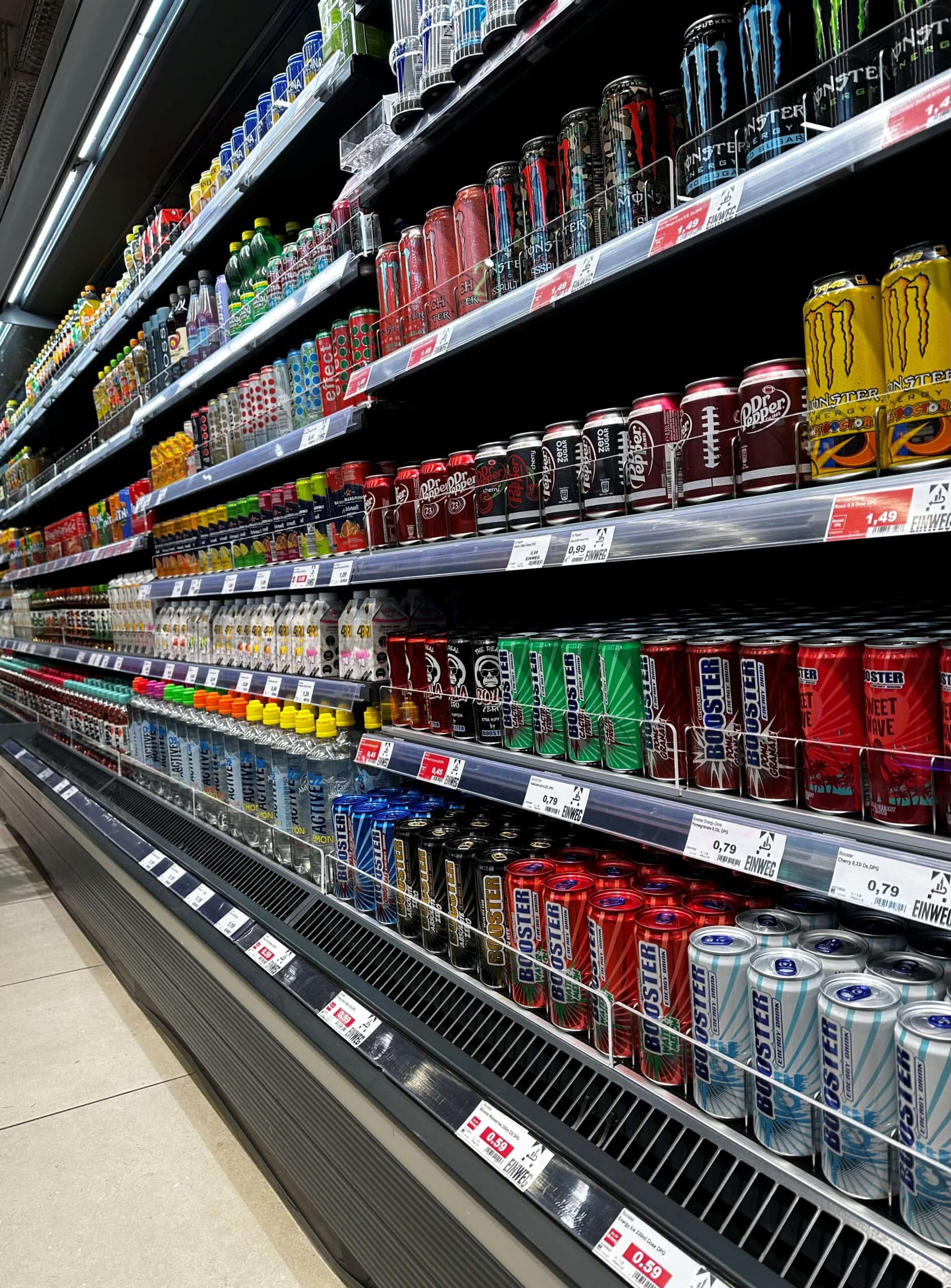 Flesenschap met diverse ijs- en energiedranken op een supermarktstandaard.
