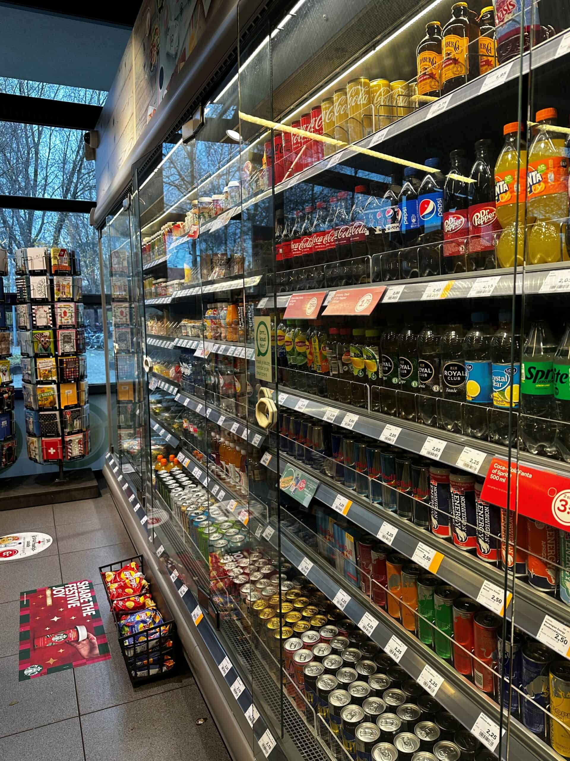 Frisdrank en frisdrank in een supermarktkoelkast, inclusief Coca-Cola, Pepsi, Fanta en andere frisdrankmerken, geschikt voor snackshops en detailhandel, met transparante glazen deuren.