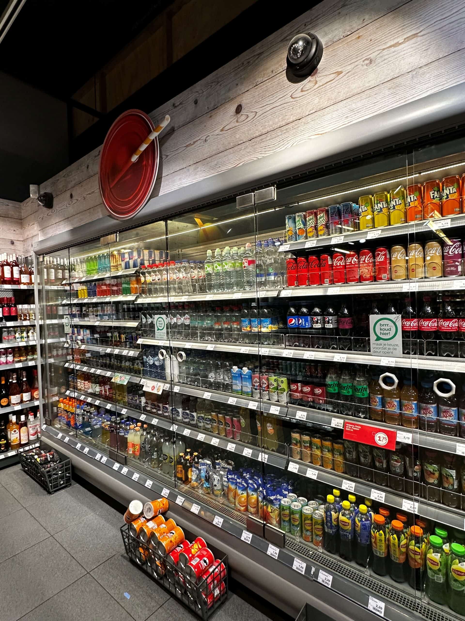 Blik met gekoelde frisdranken en waterflessen in supermarkt, detailhandel, winkel, koeling, dranken, consumptie, verfrissing, aankoop, supermarktuitrusting, frisdrank en frisdrankmerken, producten, etalage.