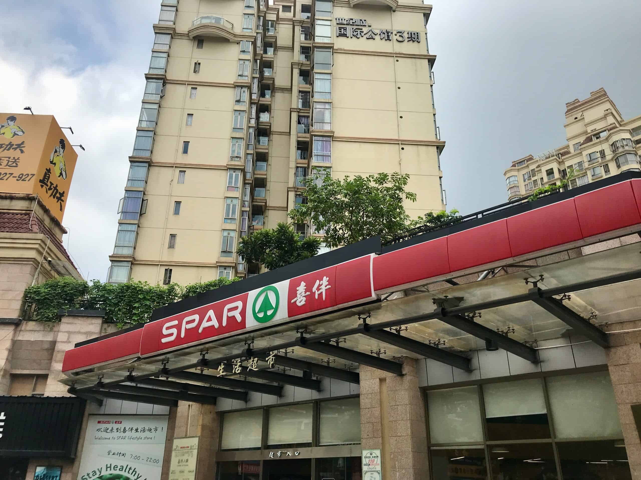 SPAR supermarkt in een stadscentrum met hoogbouw, moderne gevel en duidelijke signalisatie, gericht op klantenbinding en bereikbaarheid.
