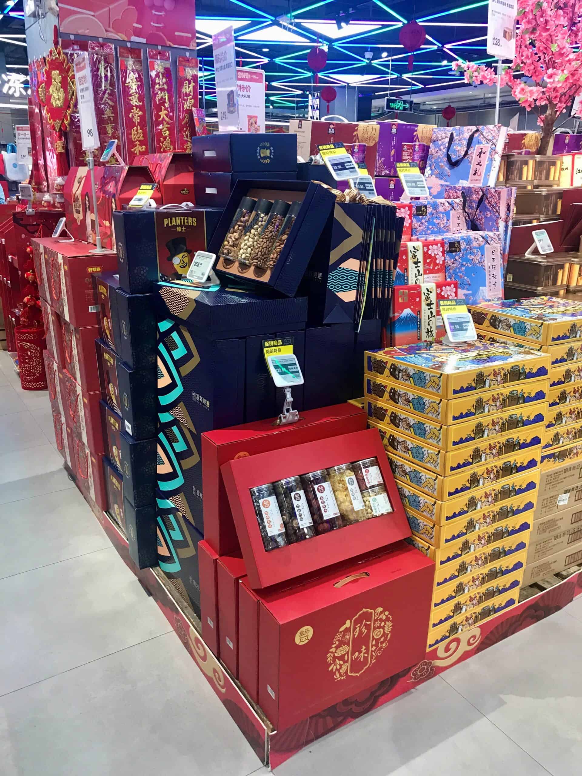 Melkproducten en snacks in kleurrijke verpakkingen, gelegen in een winkel met neonverlichting, met traditionele en internationale lekkernijen voor de feestdagen.